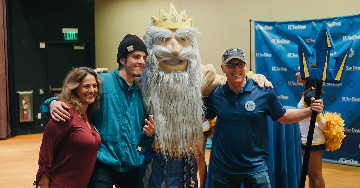Family taking a photo with King Triton mascot