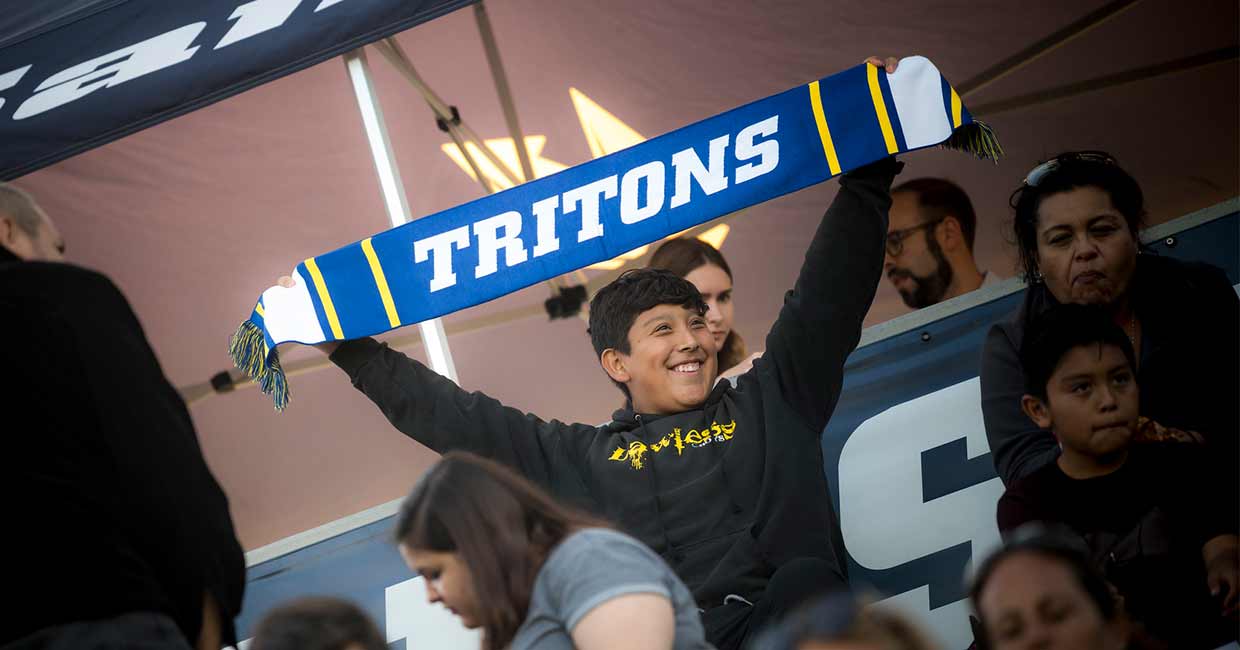 Boy cheering with Triton banner