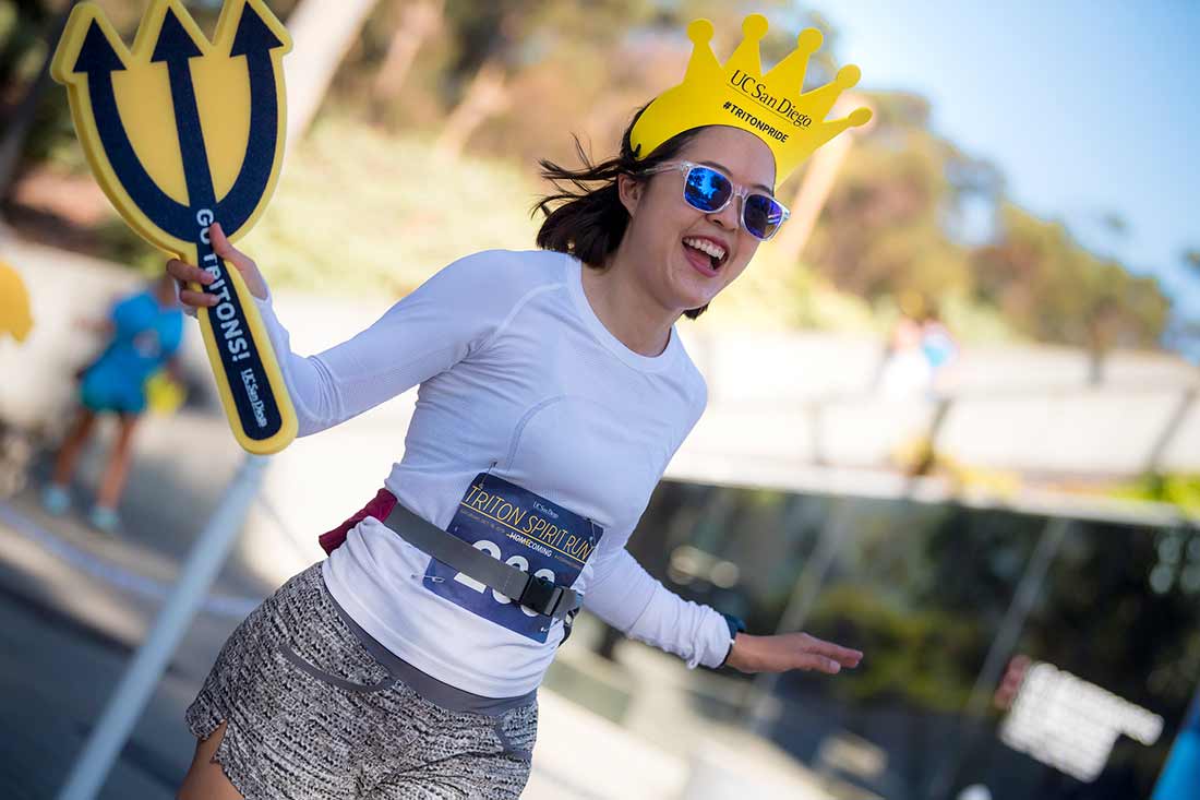 Triton 5K runners wearing a crown and holding a trident