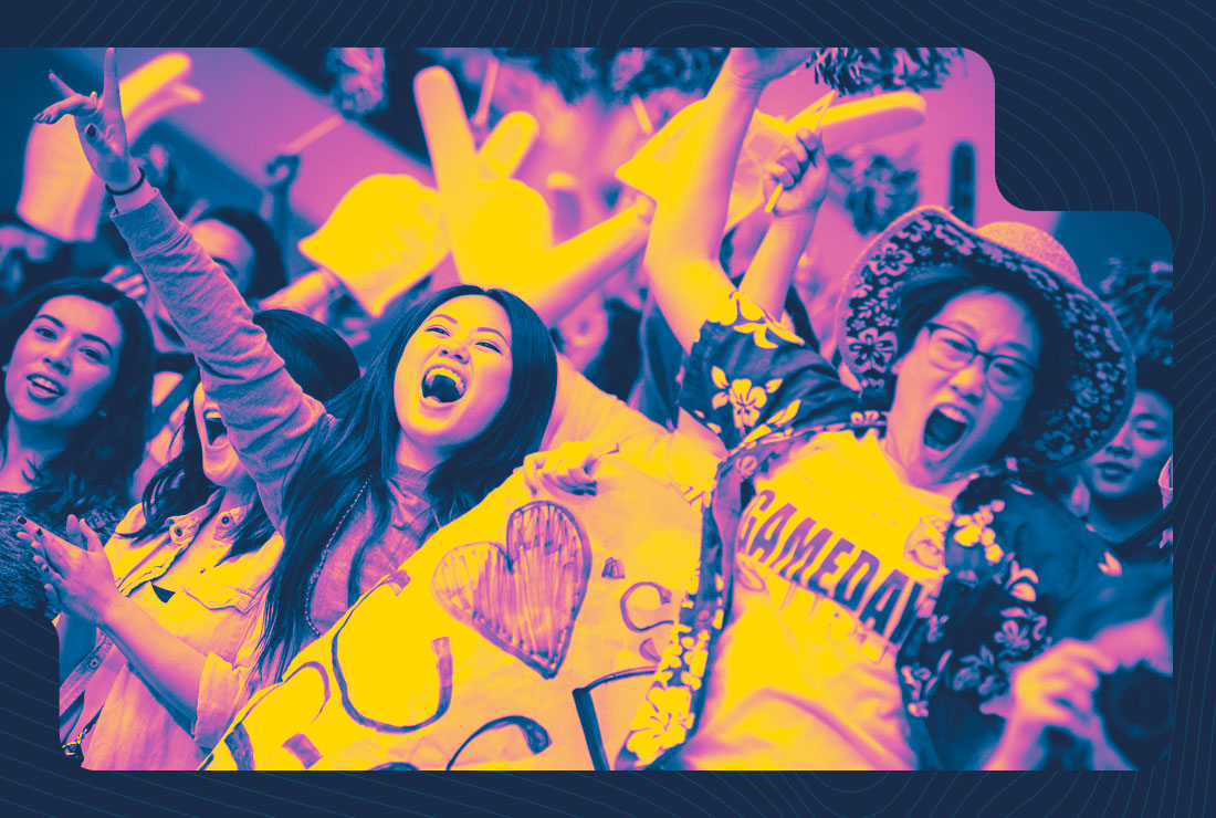 Man and woman cheering in a big crowd